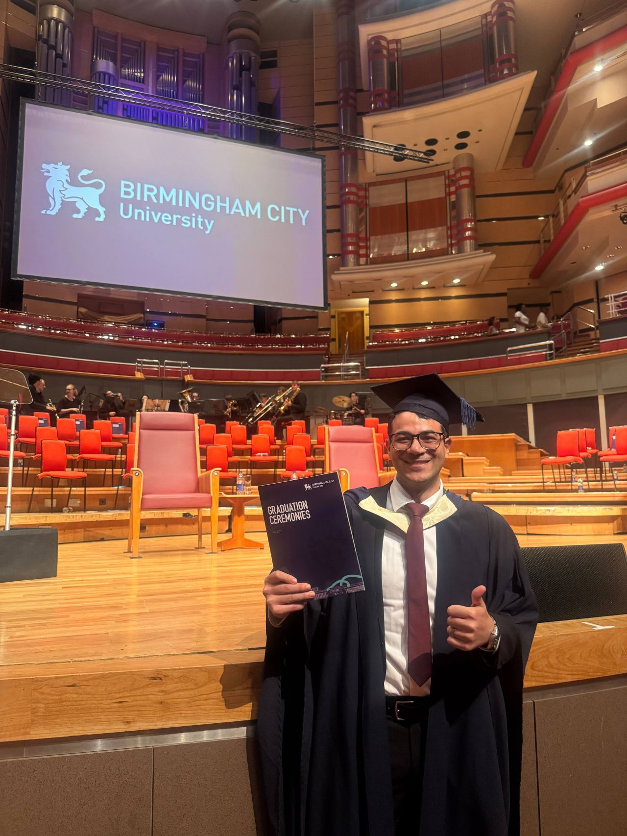 Mohamed Shrief in academic dress at a Birmingham City University graduation ceremony